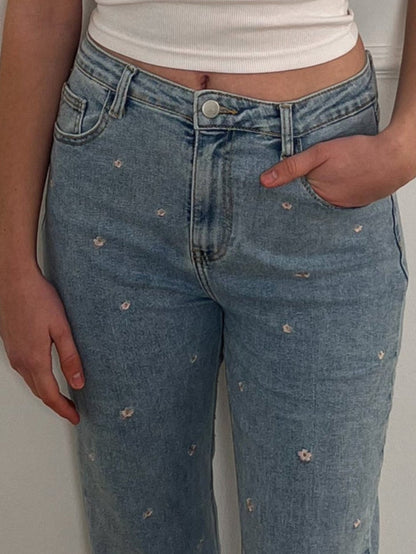 Frau mit Jeans, die ein rosanes Blumenmuster hat